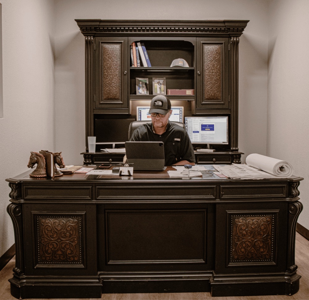 A worker at a large desk in an office