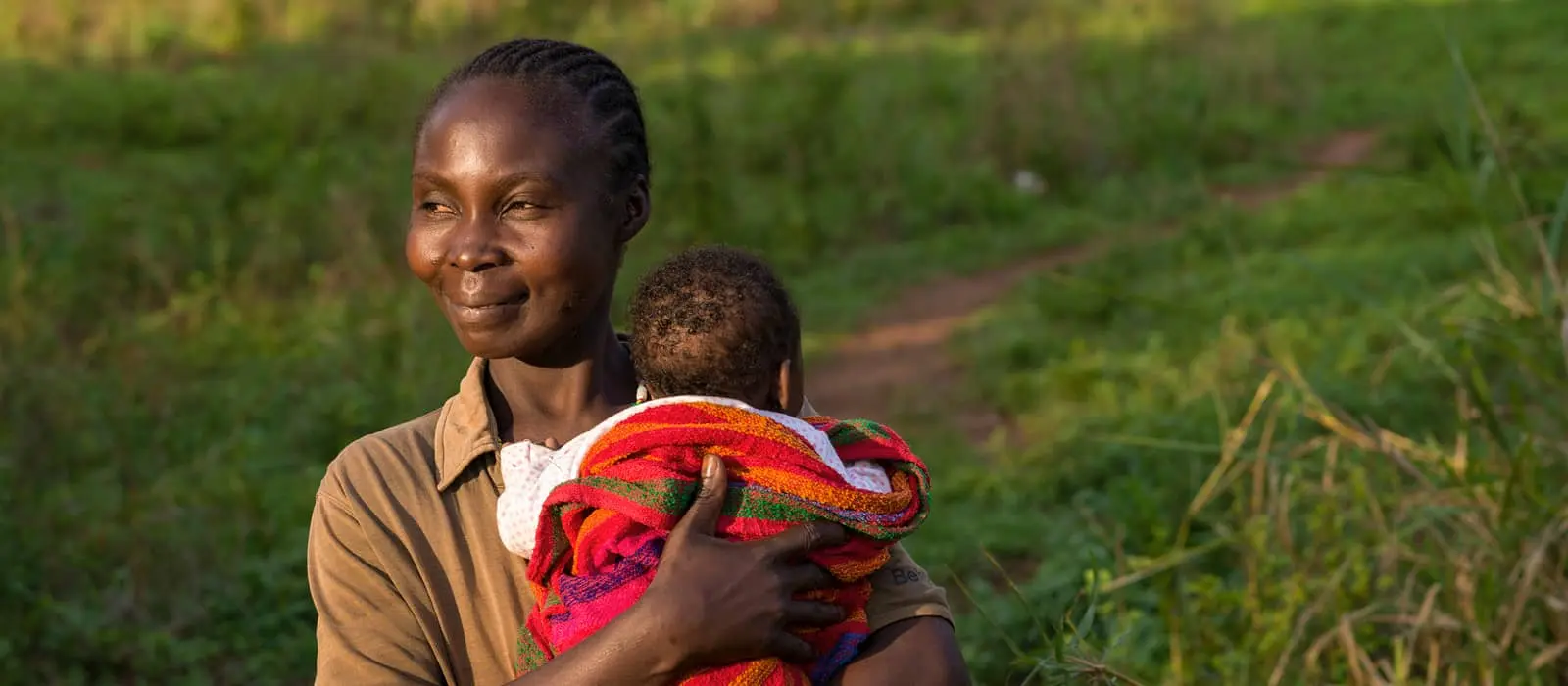 Natalie Wato holding her five-week-old son Sauvenator on the small plot of land the family tends near their home.