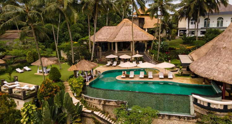 Lush pool area with Balinese architecture.