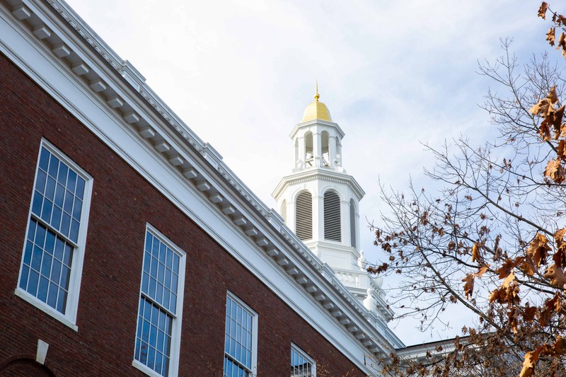 Closeup view of the white and gold spire of Baker Library at Harvard University
