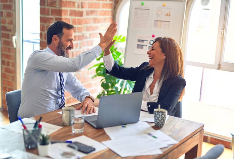 Power Automate Desktop Frau und Mann sitzen am Tisch mit Laptop