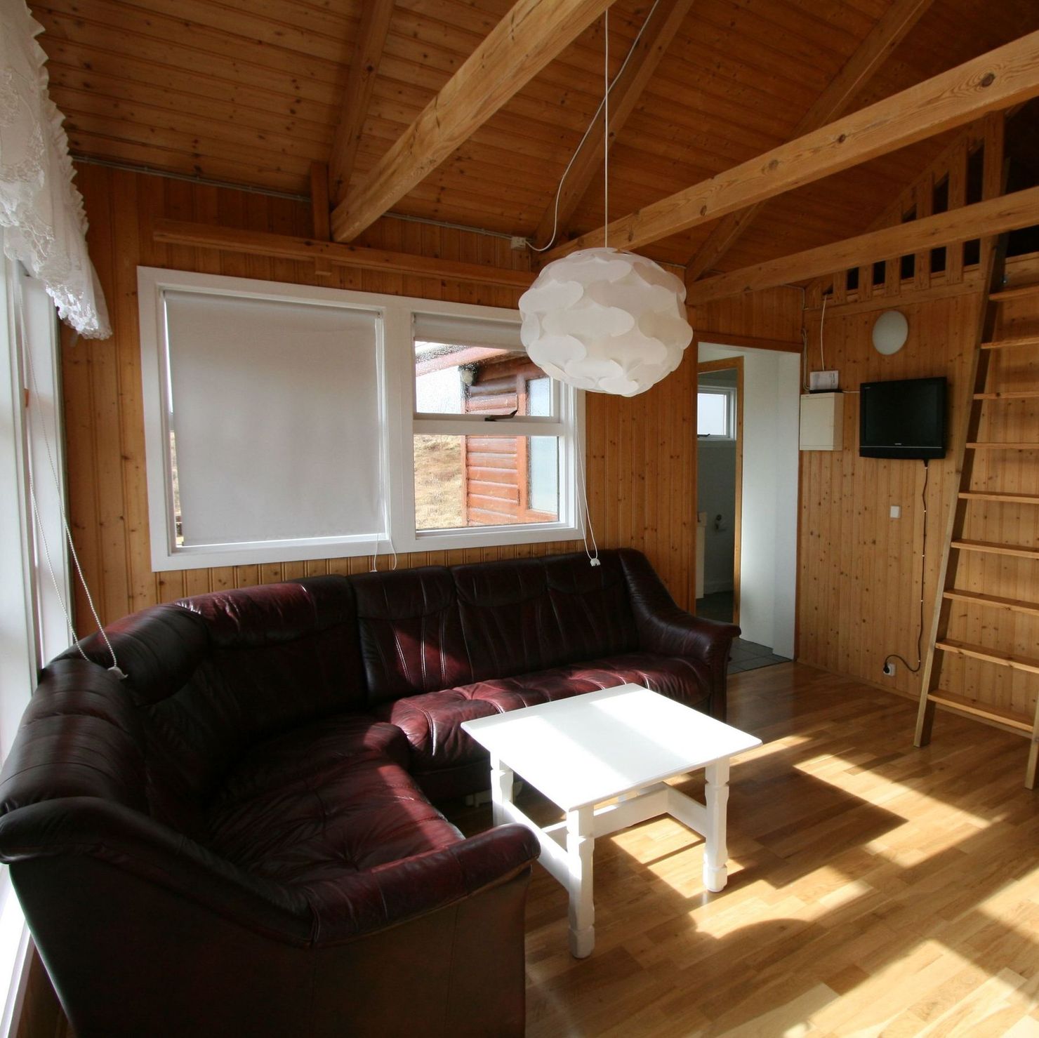 The living area with a large corner couch as well as the ladder to the loft