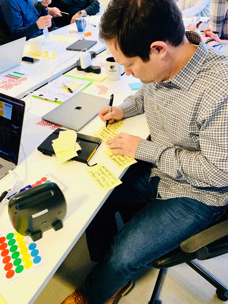 A person writing post-it notes during a Design Sprint