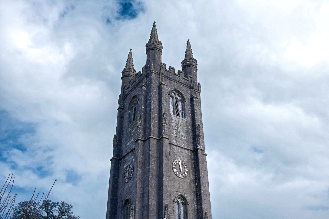 A photograph of an old church against a cloudy, blue sky