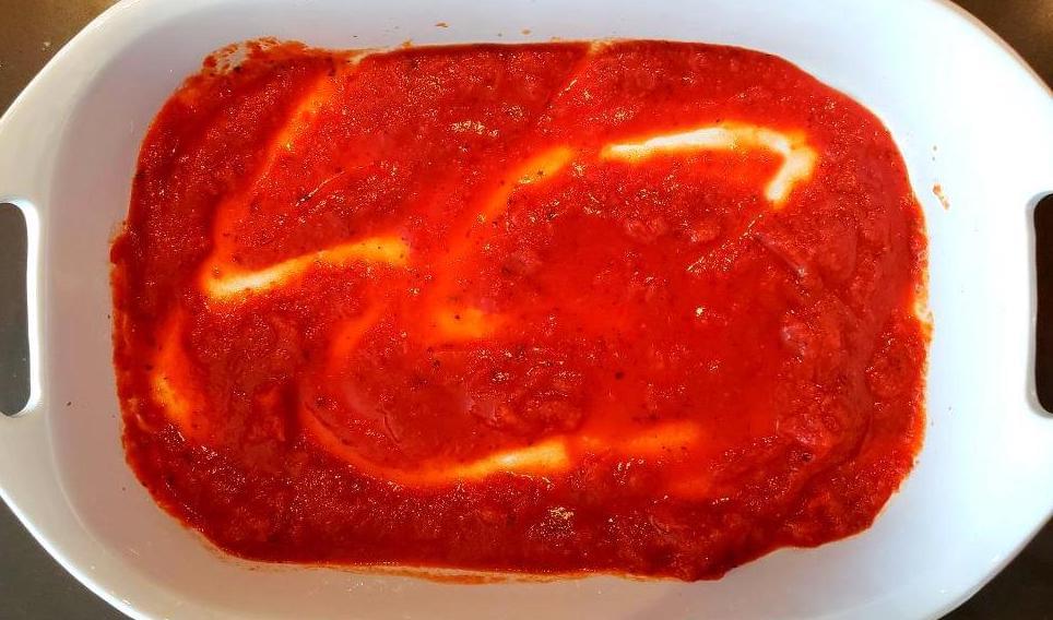 Layer of tomato sauce in bottom of casserole dish