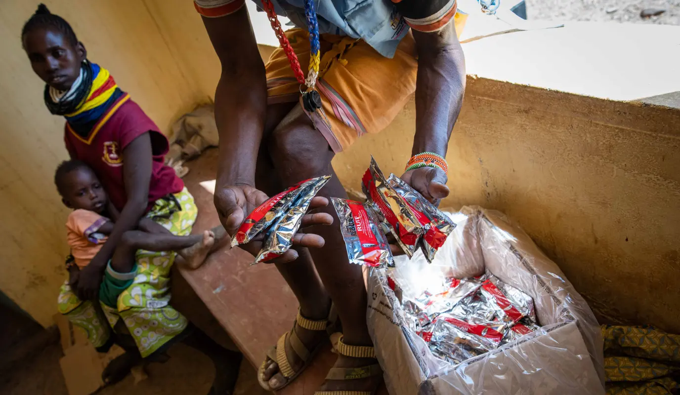 Packets of RUTF are handed out to parents of children with malnutrition at a clinic in Lekwasimyen, in Kenya's Turkana province.