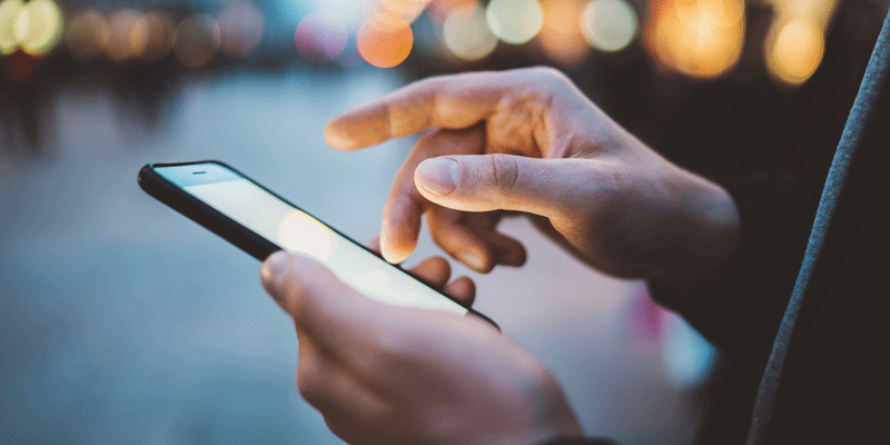 A UI designer scrolling through a mobile interface A UI designer scrolling through a mobile app on their smartphone