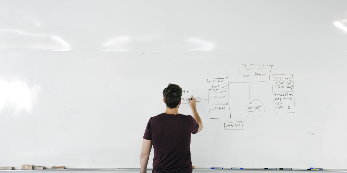 Are UX bootcamps really worth it? A newly qualified UX designer drawing on a whiteboard A newly qualified UX designer drawing on a whiteboard