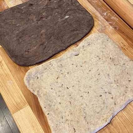 Remove the dough from the bowl and divide into two sections. Mix in the black cocoa/rye flour mixture into one half of the dough, kneading until well combined and uniform in color. I did this by hand with the help of a bench scraper. Roll both sections of dough into separate 8"x8" squares.