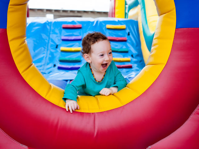 A toddler playing in a bounce house