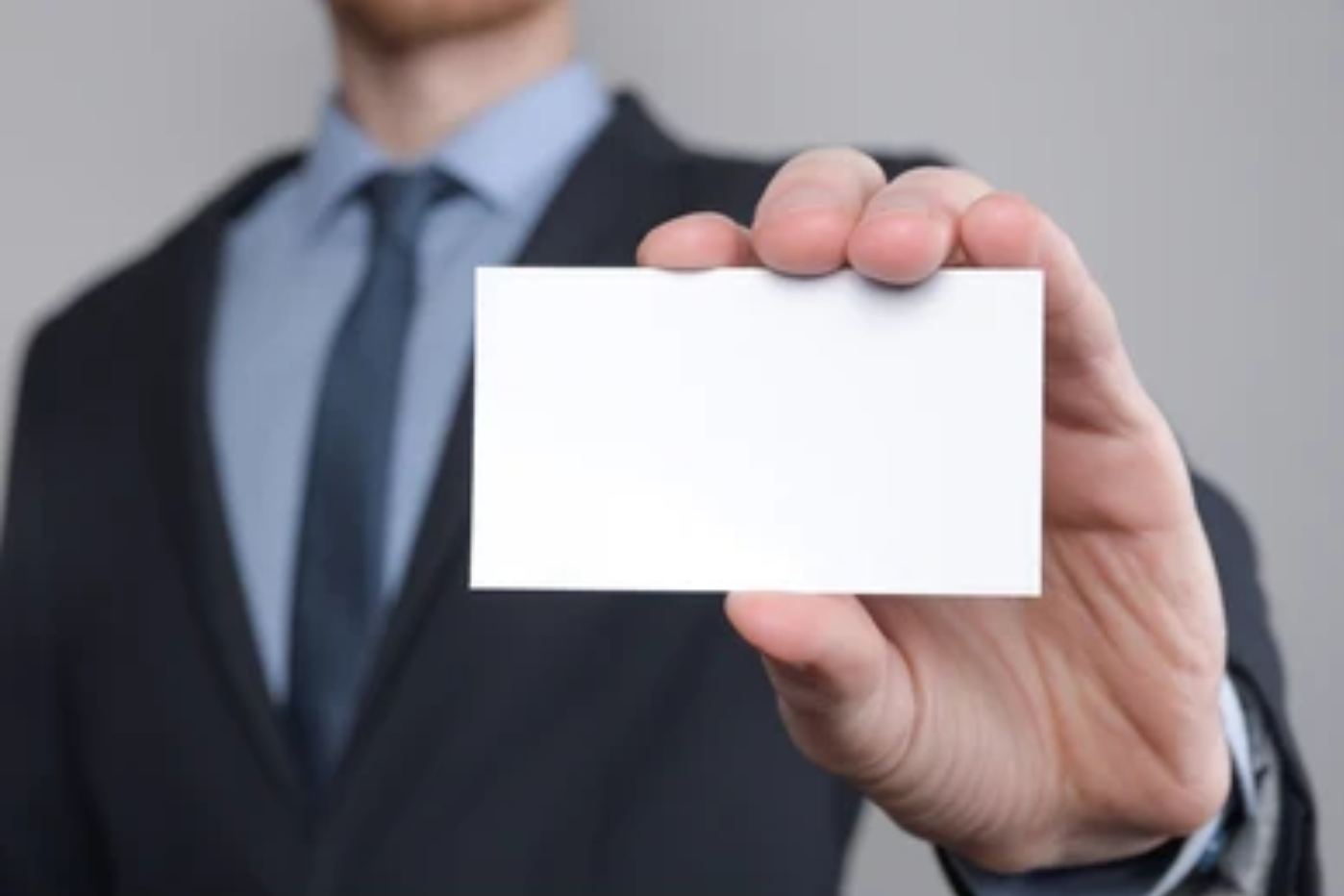 a man in a suit holding a white business card