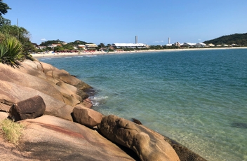 Vista das pedras da lagoinha do norte com mar a esquerda e a faixa de area ao fundo.