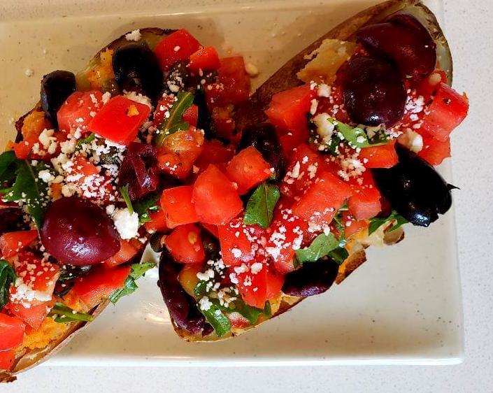 Plate with Mediterranean stuffed potatoes topped with bruschetta