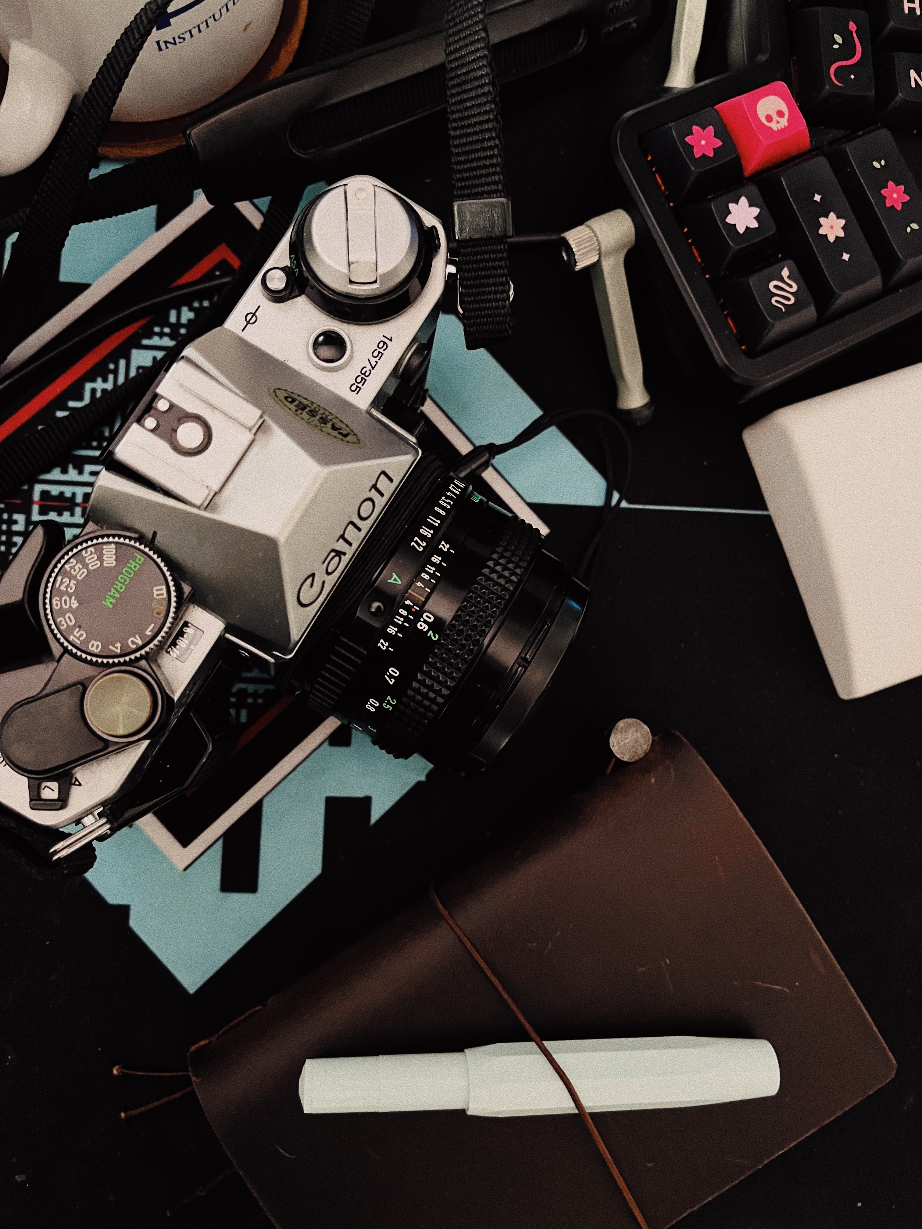 A film camera, traveller’s notebook, and fountain pen on my desk.