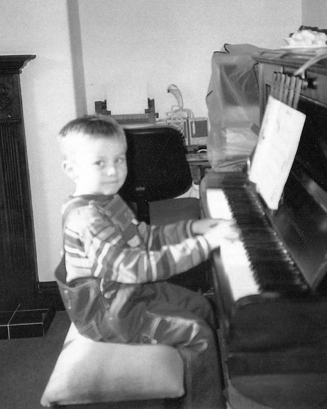 Jack Watkins as a child playing the piano