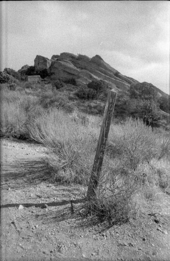 A trail marker near the rocky outcropping