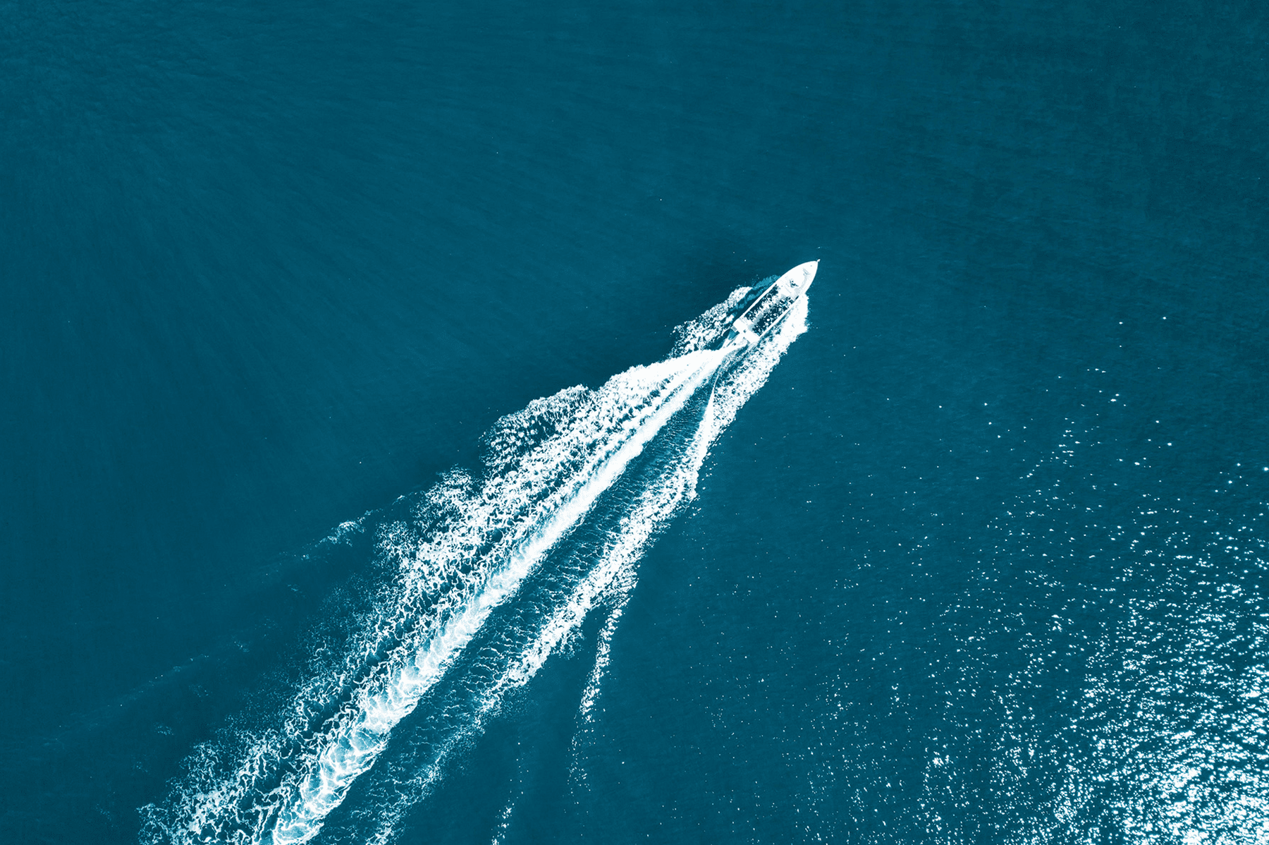 aerial shot of speedboat going across blue sea
