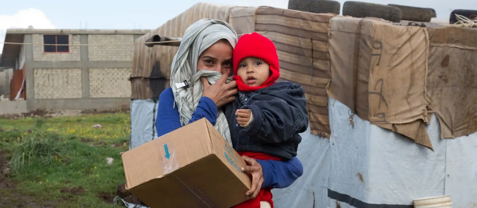 Syrian refugee holds her son.