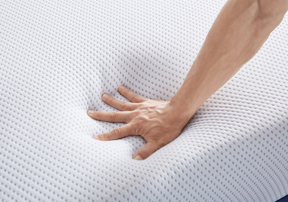A hand pressing on mattress