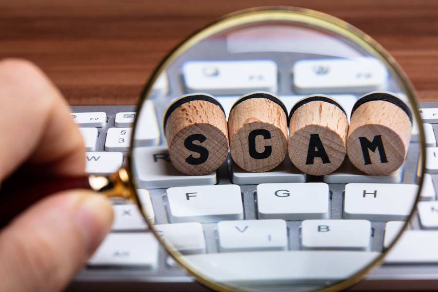 Magnifying glass highlighting letters reading "scam"