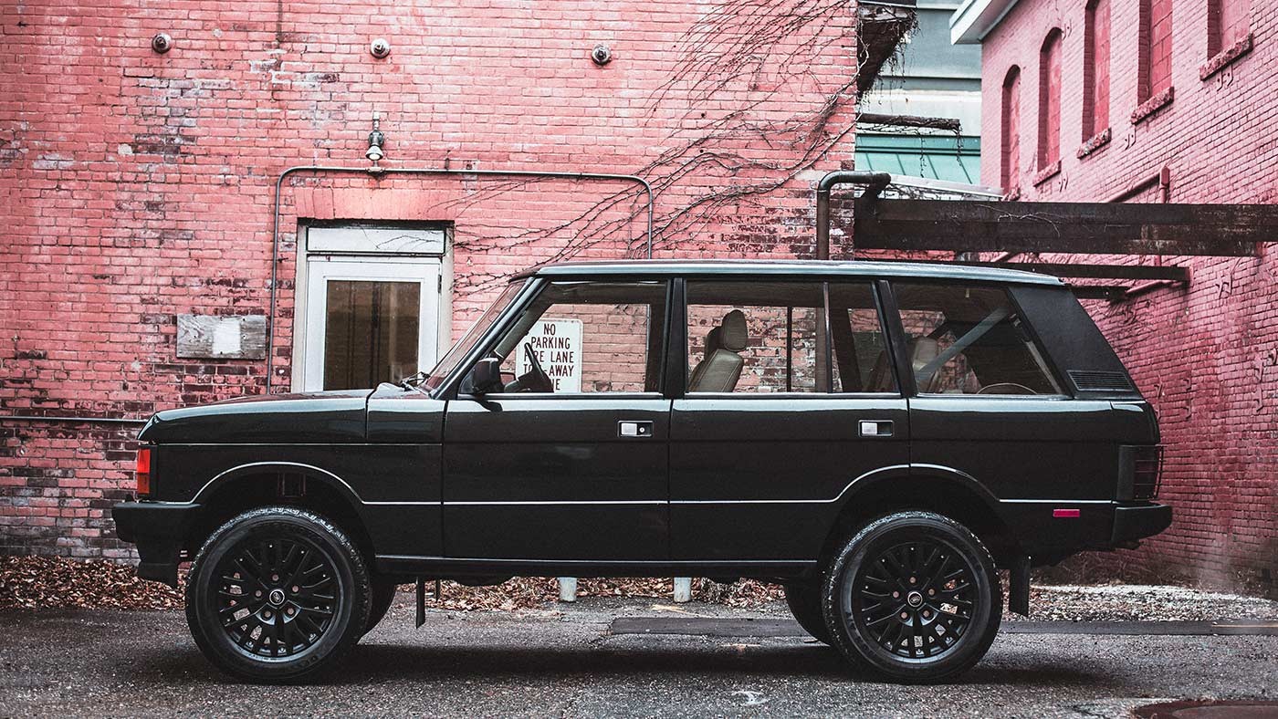 range rover classic parked in front of brick wall