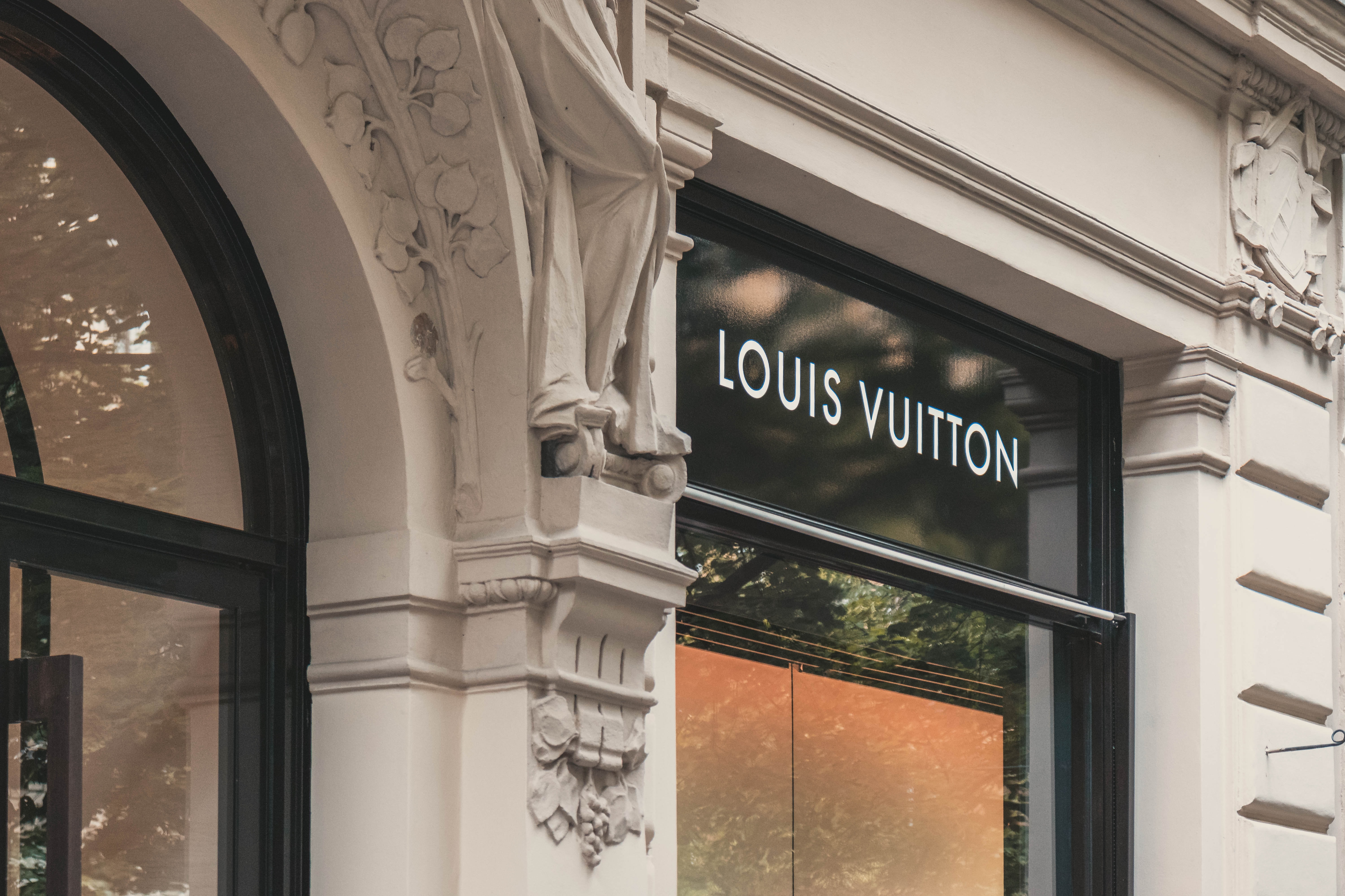 A Louis Vuitton storefront with a closeup on the brand name.