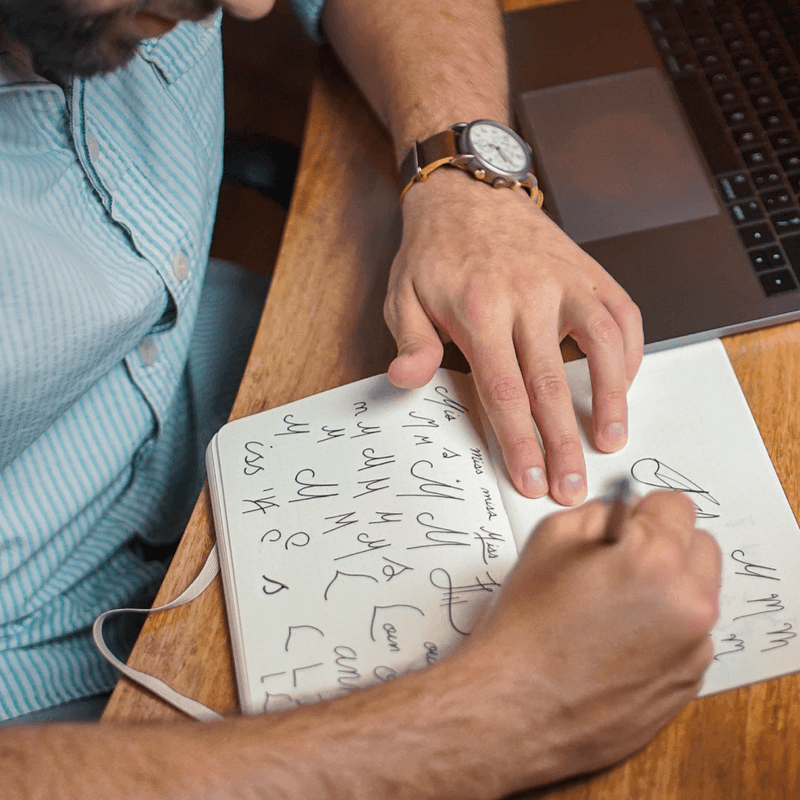 Man drawing logos in a notebook