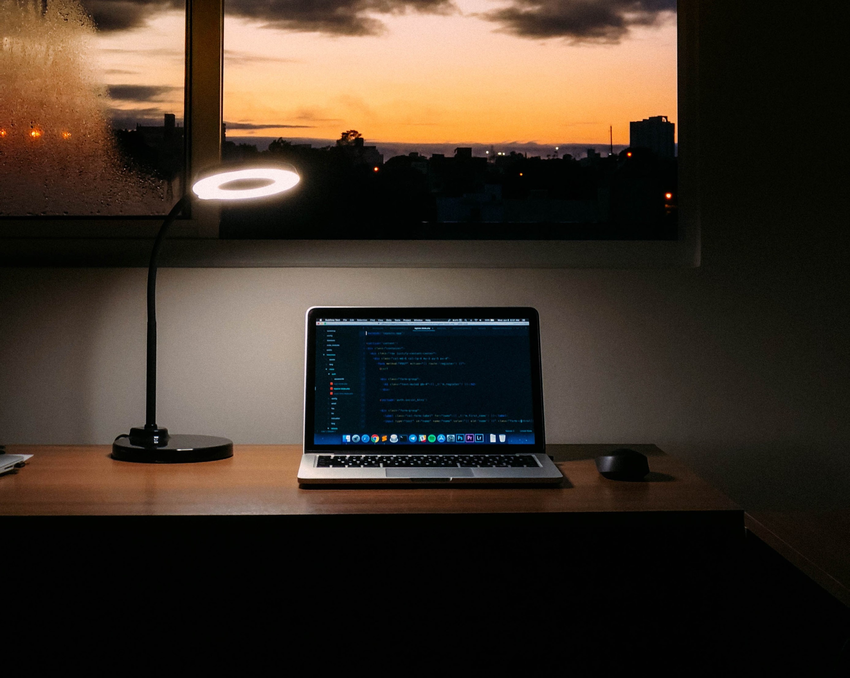 Photo by Jefferson Santos of a macbook with the sunrise outside