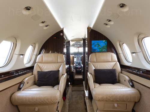 Private jet interior with straight ahead view of cream leather seats and view of the aircraft cockpit Google Meet background