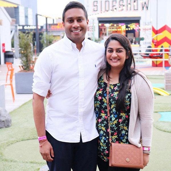 photo of Sumita & Anuj Patel standing side by side, smiling, in an outdoor public setting