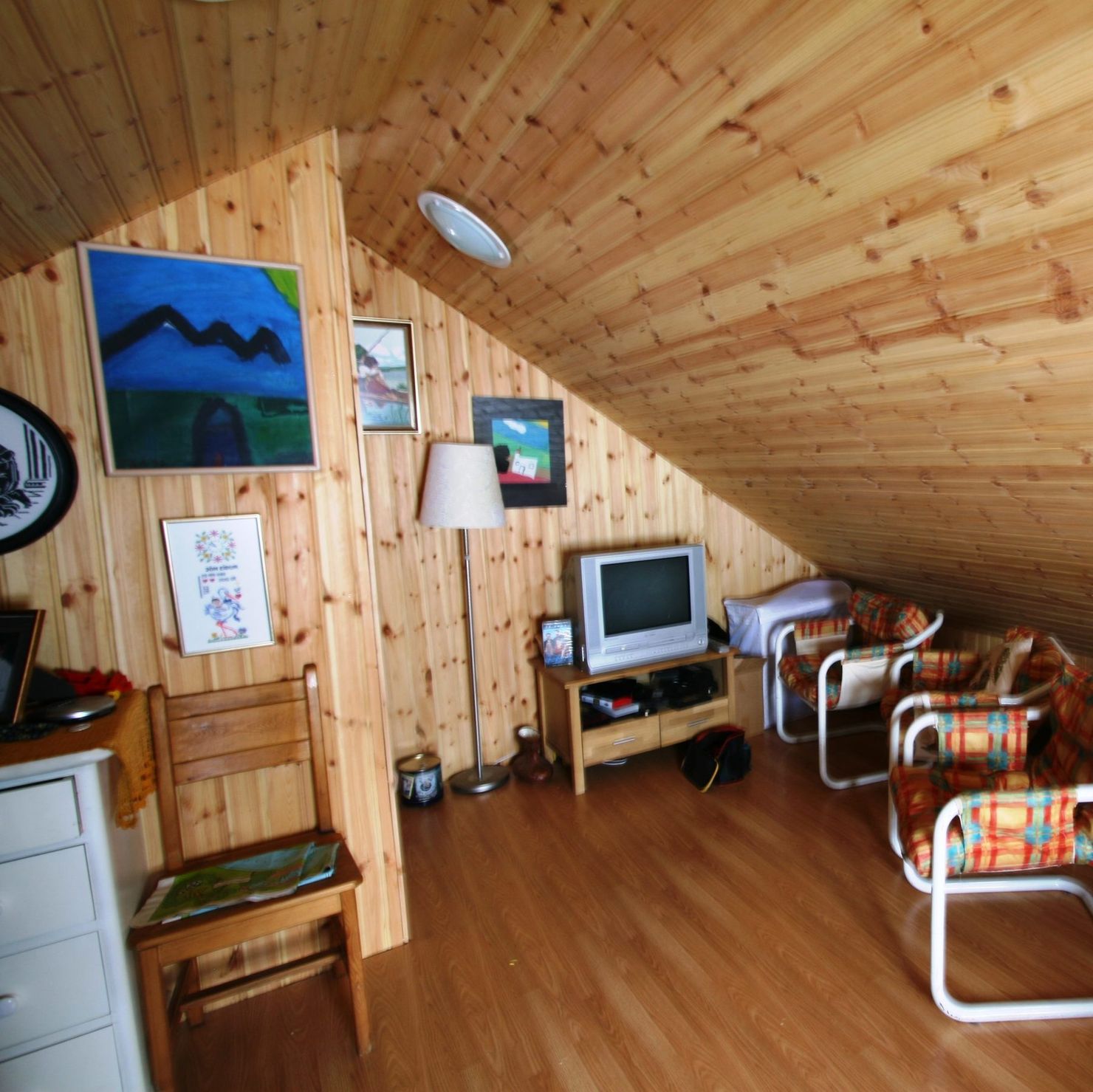 Attic with single bed, TV and chairs