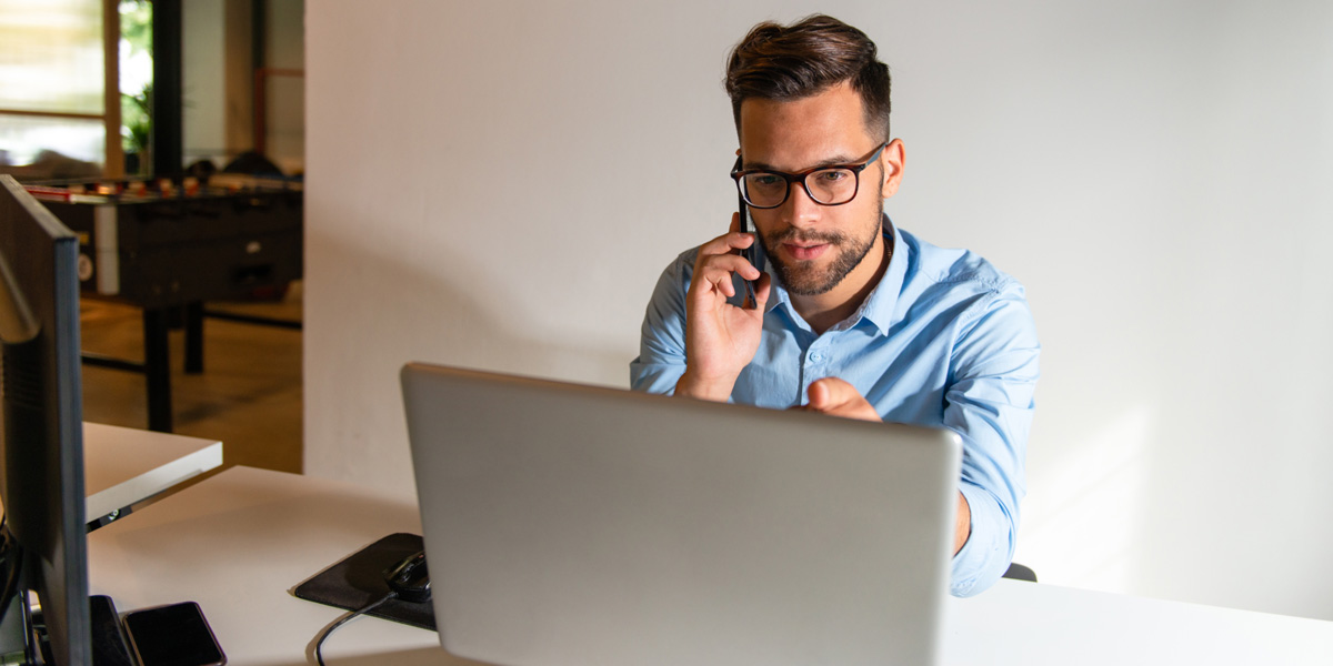 What are some examples of big data in the real world? A man sitting in front of a laptop, speaking on the phone