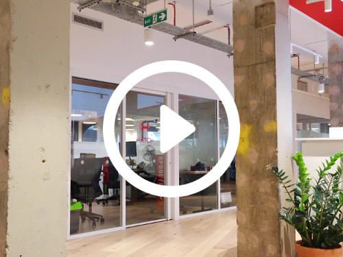 Industrial style workspace featuring floor to ceiling interior windows and wooden floor design Zoom background