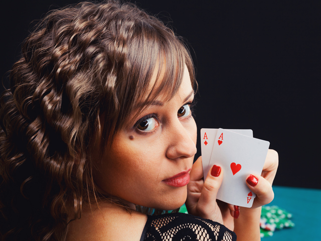 A woman holding a pair of aces in the Asshole Drinking Game