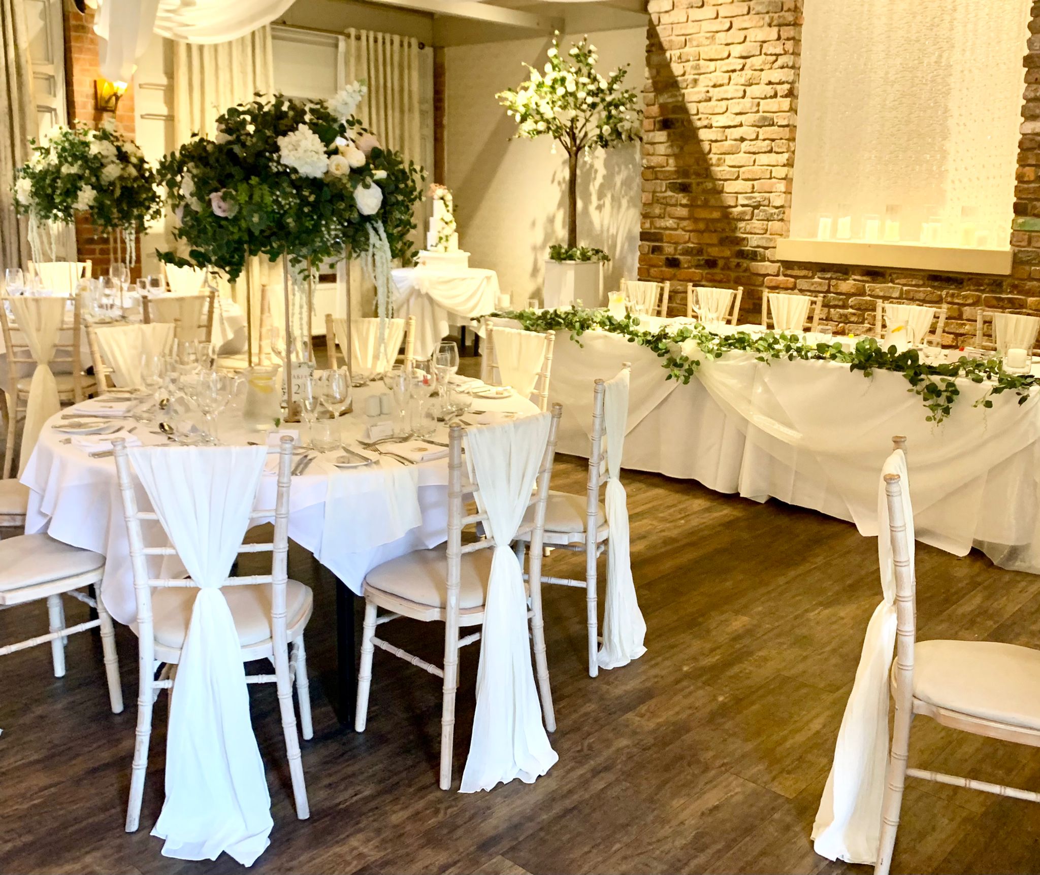 rustic wedding breakfast with white pretty chairs and flowers