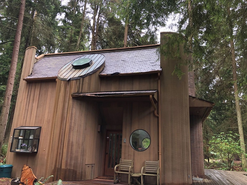 brown wooden home with broken gutters
