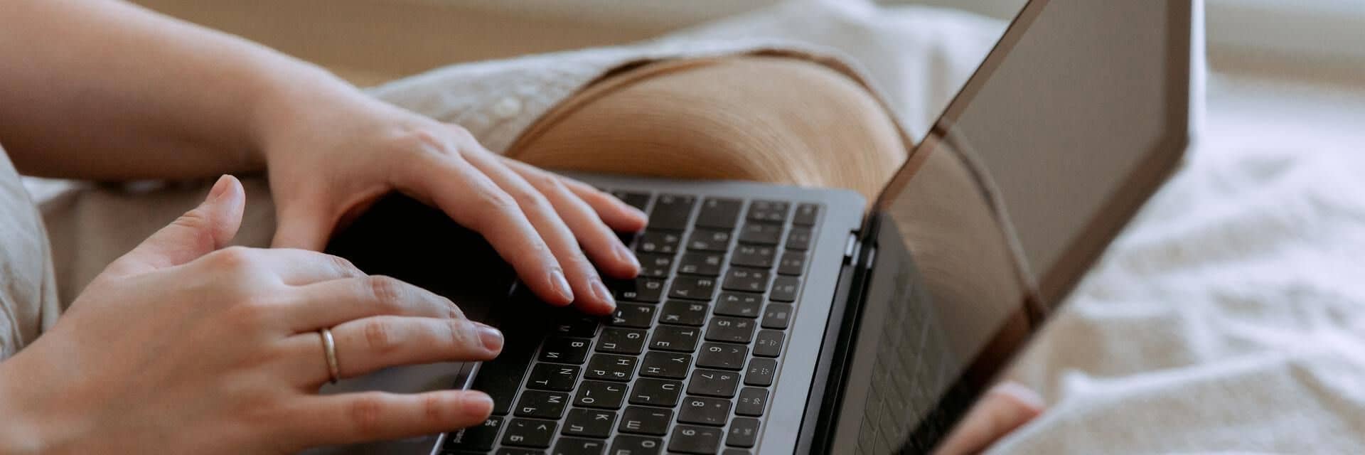Teilnehmerin mit Laptop während einer Live-Online Schulung Teilnehmerin mit Laptop während einer Live-Online Schulung auf ihrem Sofa