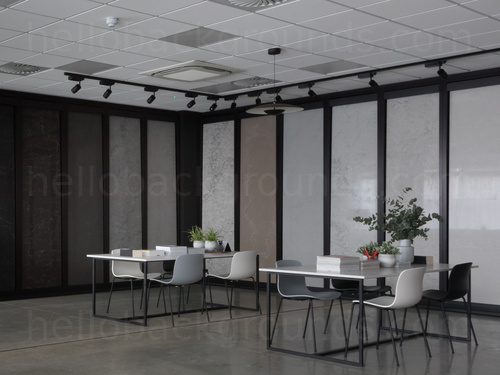 Modern shared workspace featuring white panel with black frame design walling behind white table with various modern chairs Zoom background