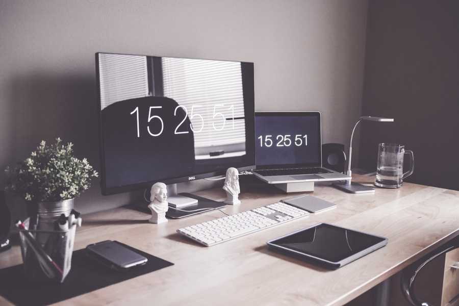 Home office set up with desktop, laptop, tablet, and mobile devices