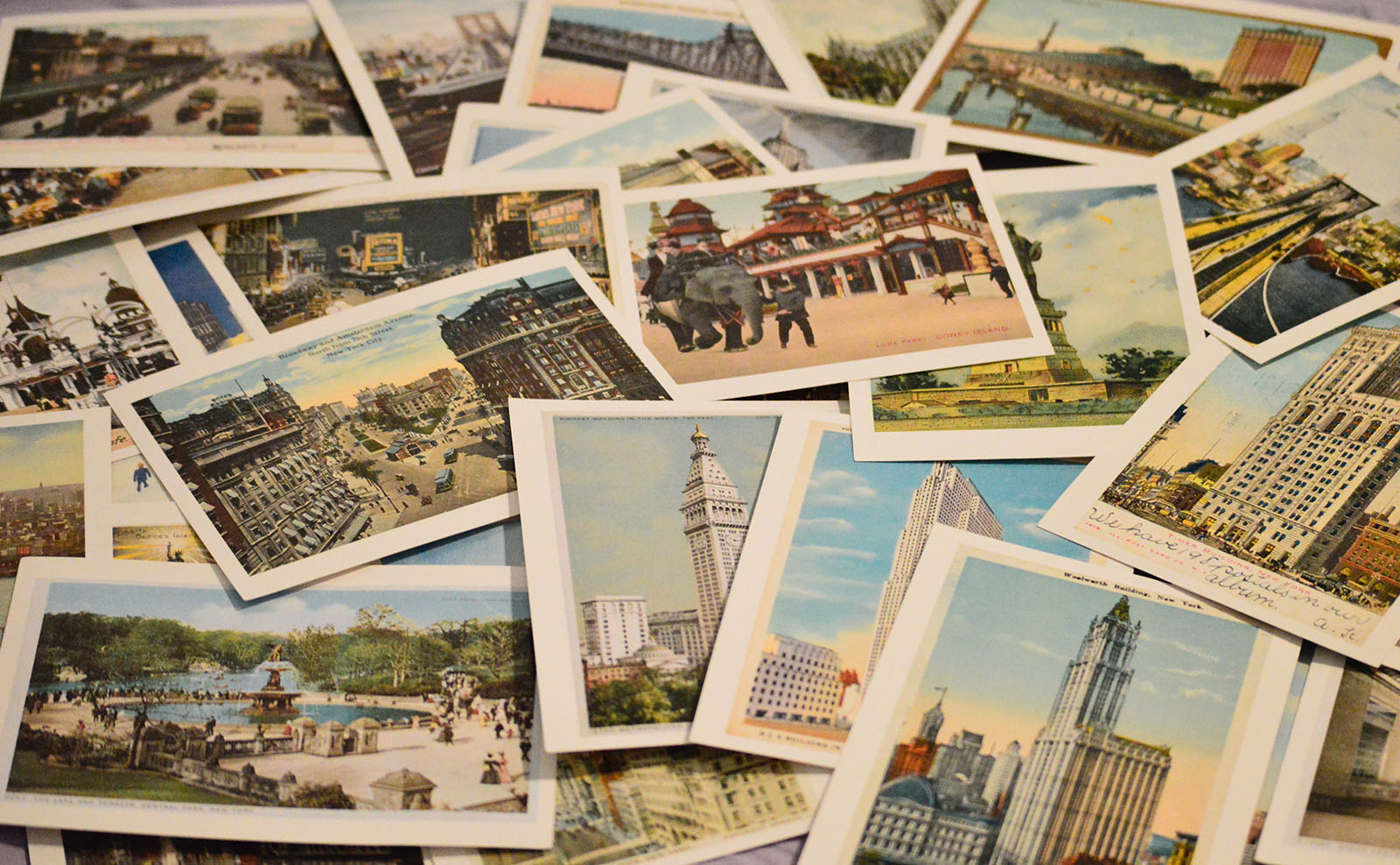 photograph of a table covered with vintage postcards of landmarks around the world