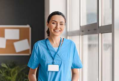 A healthcare professional smiles while working in a medical setting