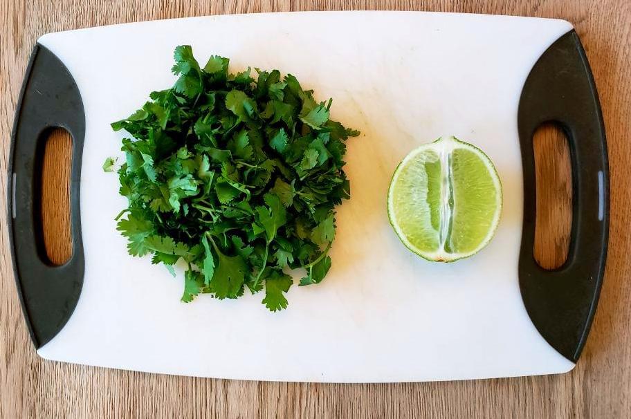 Cutting board with chopped cilantro and half a lime