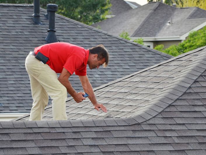 Man inspecting roof with device