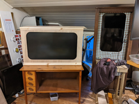 TV screens on a desk and in a corner cabinet