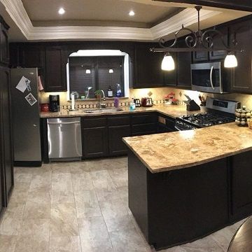 black cabinets with black walled kitchen and light brown counters