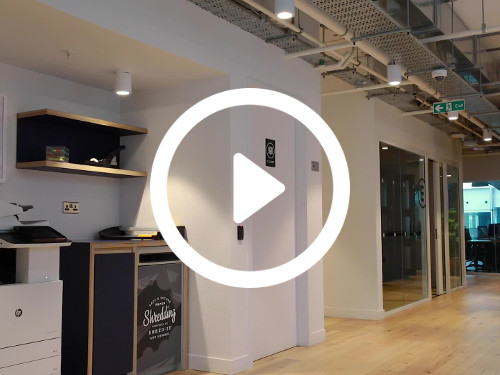 Spacious workspace featuring exposed ceiling and modern lighting design above simple wooden floors Microsoft Teams background