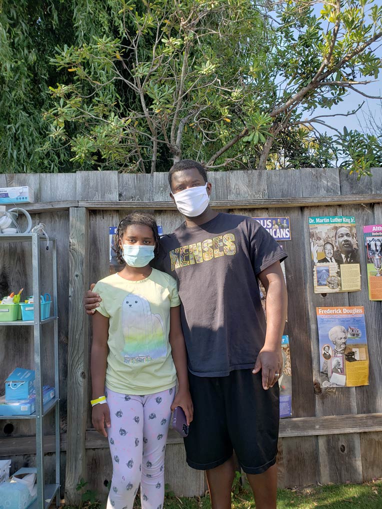 Brian Doss and one of his daughters standing together wearing masks