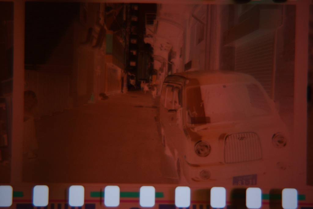 Photographic Negative of a car in an alleyway
