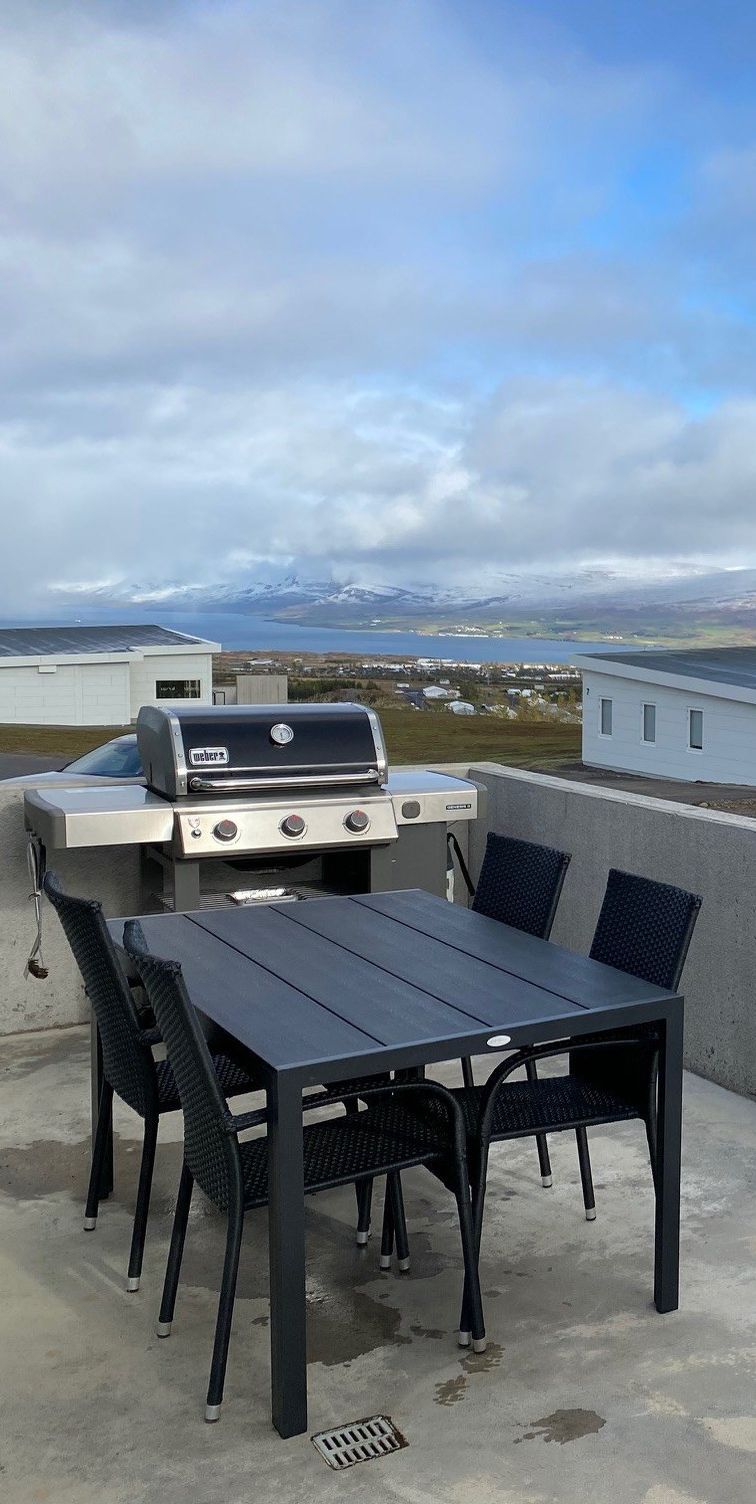 The terrace with a gas grill and a table.