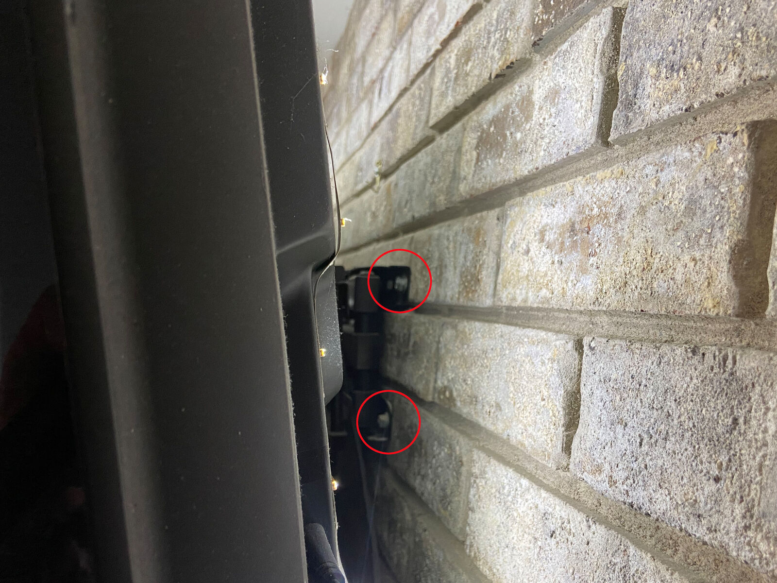 close up of lag bolts in masonry holding up TV mount
